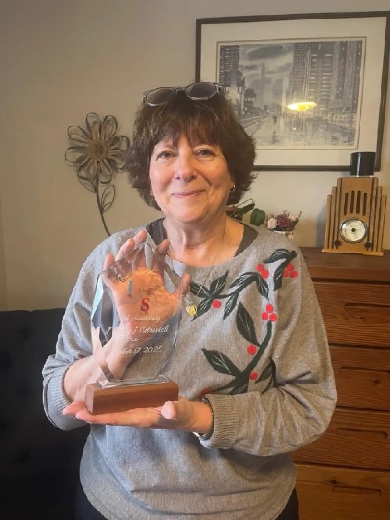 Mary Mitrovich holding an IFSI plaque honoring her 20 years at IFS-I