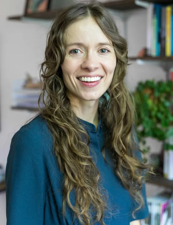 Headshot of Elizabeth Droppers with bookshelves in the background. 