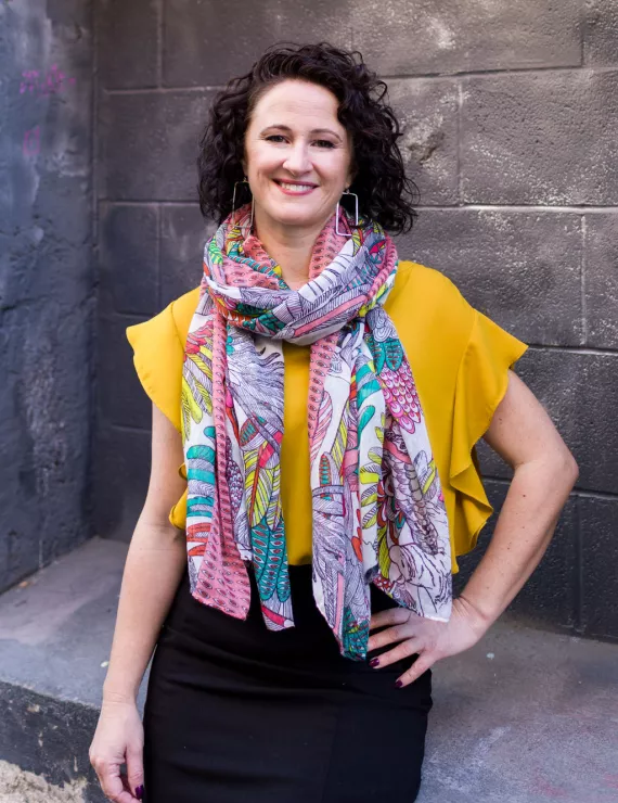 Ellie Vargas, IFS clinician and consultant, is shown wearing yellow blouse and multi-colored scarf