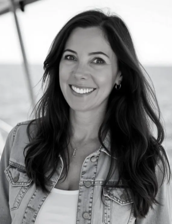 b&w headshot on a boat with the ocean behind.