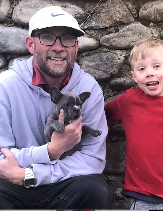 endearing photo of man, son, and puppy. 
