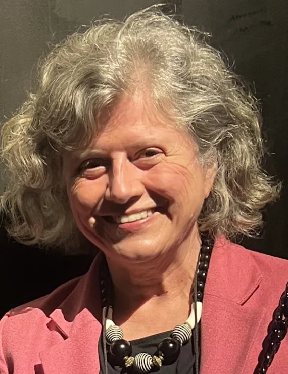 White woman, white and short hair, with a pink coat